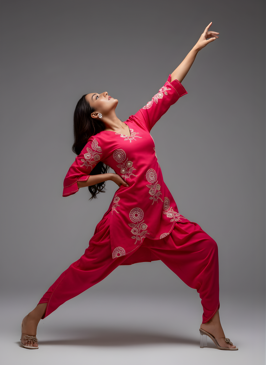 Dancer in a bright pink traditional outfit with white patterns on a gray background