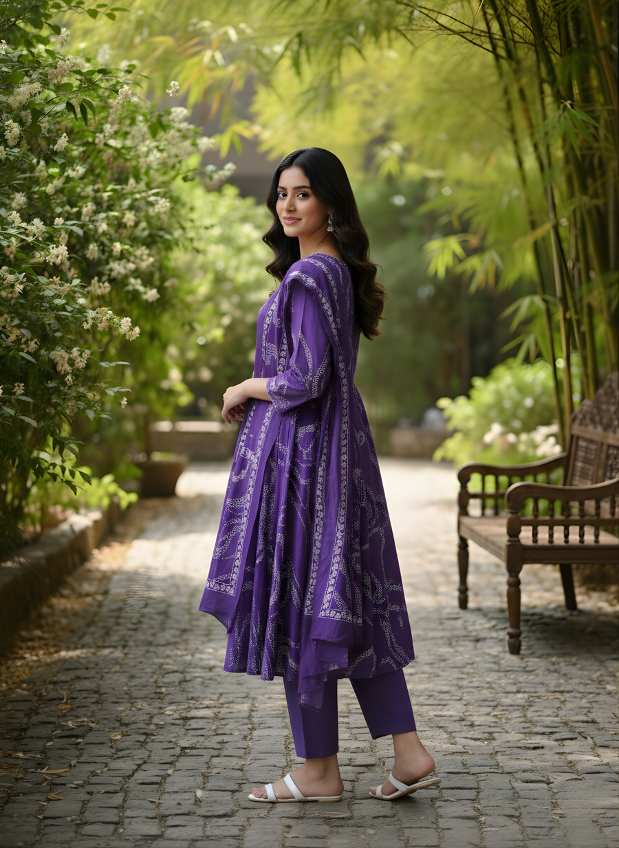 Woman in a purple outfit standing in a garden setting